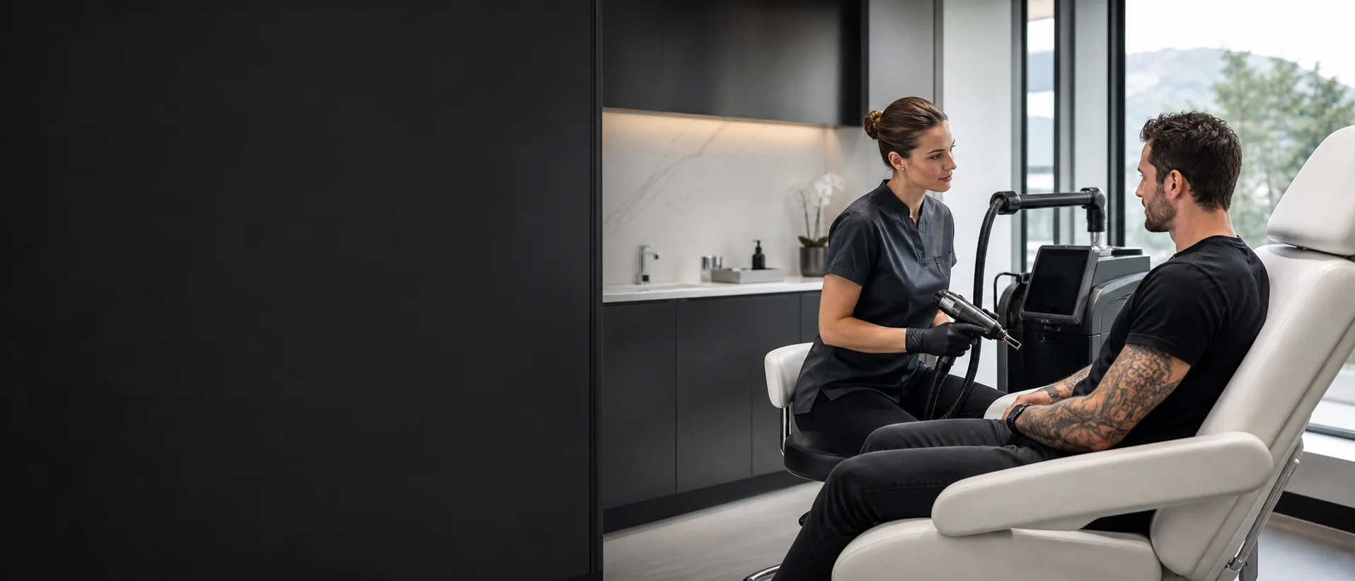Laser practitioner consulting with a tattoo-removal customer in a modern clinic